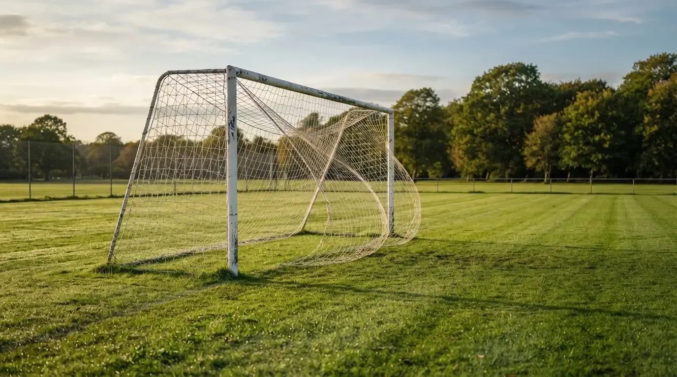 Ein Fussballtor mit locker hängendem Netz auf einem Trainingsplatz, das sich leicht im Wind bewegt.