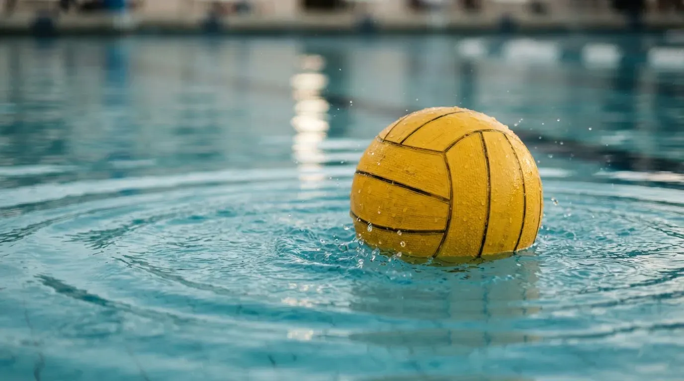 Ein gelber Ball treibt auf ruhigem türkisfarbenem Beckenwasser, feine Wellen im weichen Licht.