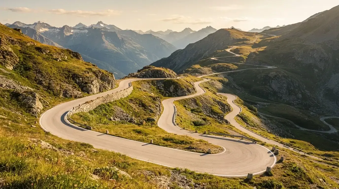 Eine Passstrasse zieht sich in Kehren einen Alpenhang hinauf, kein Fahrzeug ist zu sehen.
